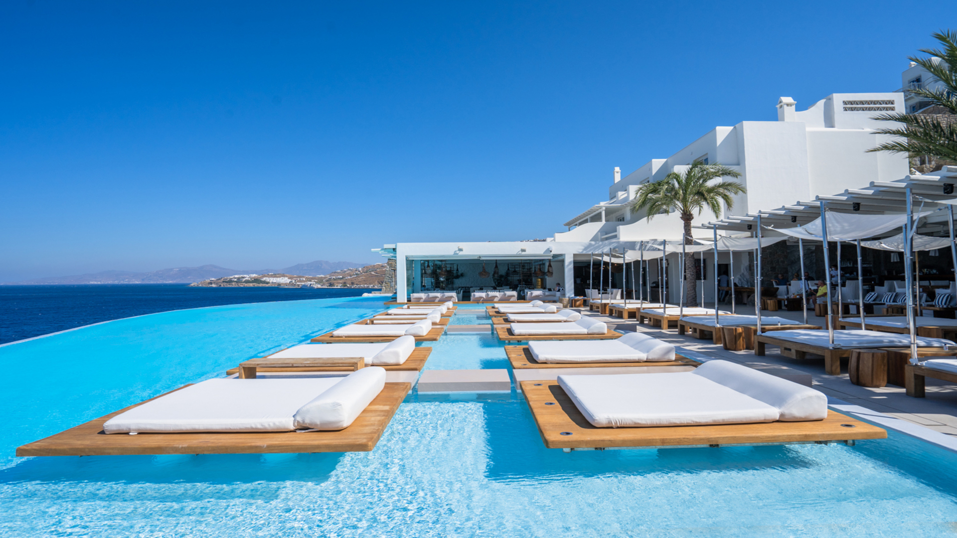 Piscina de borde infinito y lounge del Cavo Tagoo con vistas al Egeo en Mykonos